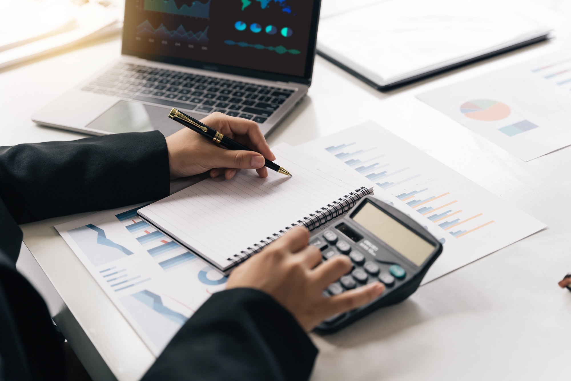 Businesswoman using calculator and laptop computer for analysis maketing plan, Accountant calculate